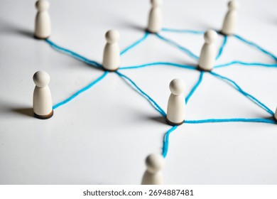 Small figures connected by string pathways, conveying community links, cooperation and coordinated effort across a shared system.
