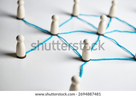 Small figures connected by string pathways, conveying community links, cooperation and coordinated effort across a shared system.
