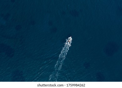 Small Fishing Boat In The Deep Blue Sea. Overhead View