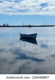 Small Fishing Boat Floating On A Mirror Lake In Magdalen Island, Quebec, Canada