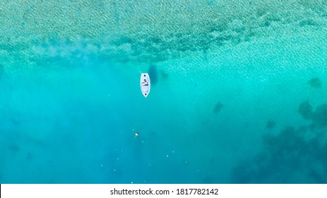Small fishing boat on turquoise  blue water of Limni Vouliagmeni or Ireon Lake, Peloponnese, Greece 