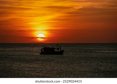 Small fishing boat is silhouetted against the vibrant orange red sky at fiery sunset near Duong Dong on Phu Quoc island, Vietnam, South East Asia. Dramatic peaceful atmosphere in Gulf of Thailand - Powered by Shutterstock