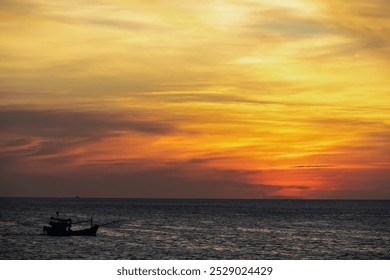 Small fishing boat is silhouetted against the vibrant orange red sky at fiery sunset near Duong Dong on Phu Quoc island, Vietnam, South East Asia. Dramatic peaceful atmosphere in Gulf of Thailand - Powered by Shutterstock