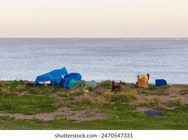 Small fishing boats all covered up, with winches close by, on the shingle beach at Kessingland, UK.  - Powered by Shutterstock