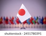 a small flag of japan is sitting in front of a row of other flags