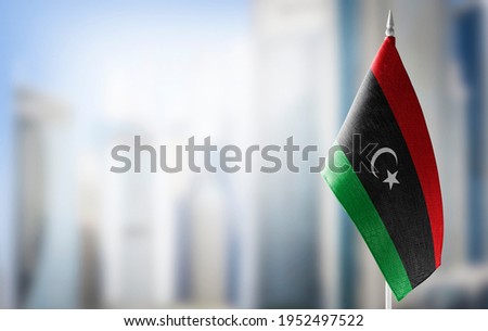 A small flag of Libya on the background of a blurred background