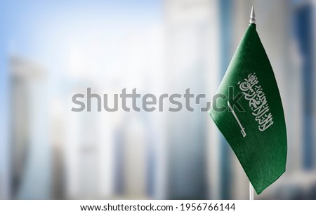 A small flag of Saudi Arabia on the background of a blurred background