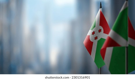 Small flags of the Burundi on an abstract blurry background.