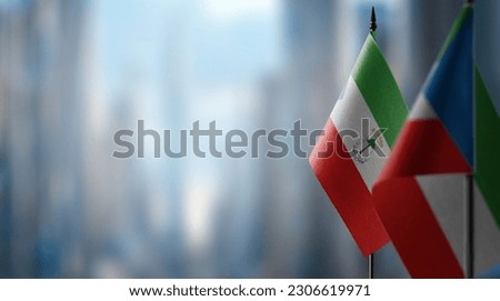 Small flags of the Equatorial Guinea on an abstract blurry background.