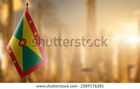 Small flags of the Grenada on an abstract blurry background.