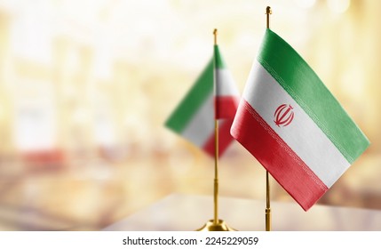 Small flags of the Iran on an abstract blurry background.
