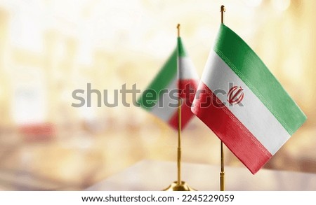 Small flags of the Iran on an abstract blurry background.