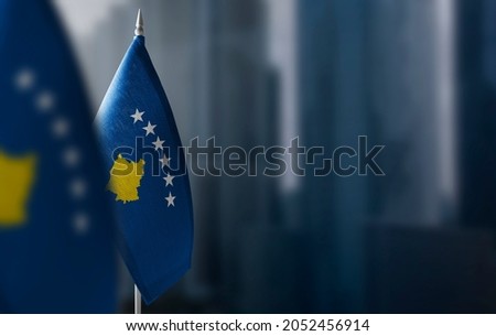 Small flags of Kosovo on a blurry background of the city