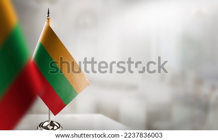Small flags of the Lithuania on an abstract blurry background.