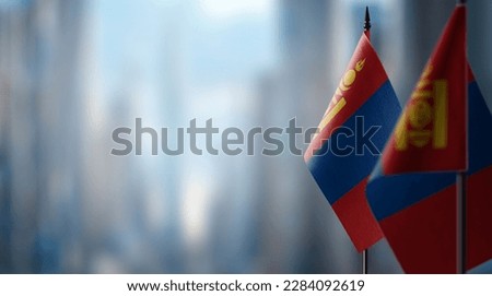Small flags of the Mongolia on an abstract blurry background.