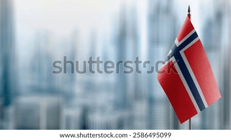 Small flags of the Norway on an abstract blurry background.
