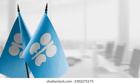 Small flags of the Organization of the Petroleum Exporting Countries on an abstract blurry background.