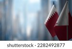Small flags of the Qatar on an abstract blurry background.