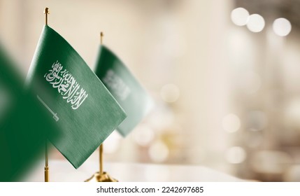 Small flags of the Saudi Arabia on an abstract blurry background. - Shutterstock ID 2242697685