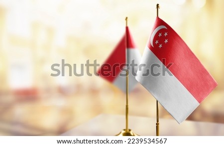 Small flags of the Singapore on an abstract blurry background