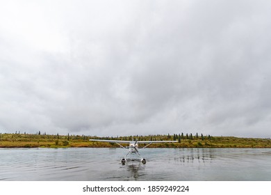 Small Float Plane Landing On River In Alaska