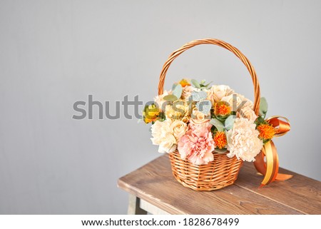 Small flower shop and Flowers delivery. Flower arrangement in Wicker basket. Beautiful bouquet of mixed flowers in woman hand. Handsome fresh bouquet