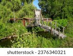 Small footbridge spanning a swampy canal in the Hortillonnages of Amiens to access a country house built on an island surrounded by the waters of the river Somme in Picardie, France