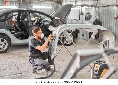 Small Garage. The mechanic works with a grinding tool. Sanding of car elements. Painting car service. Repairing car section after the accident. - Powered by Shutterstock