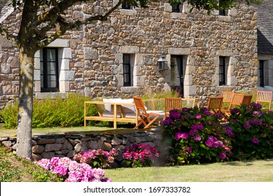 Small Garden In Front Of A Stone House In The South Of Brittany In France.