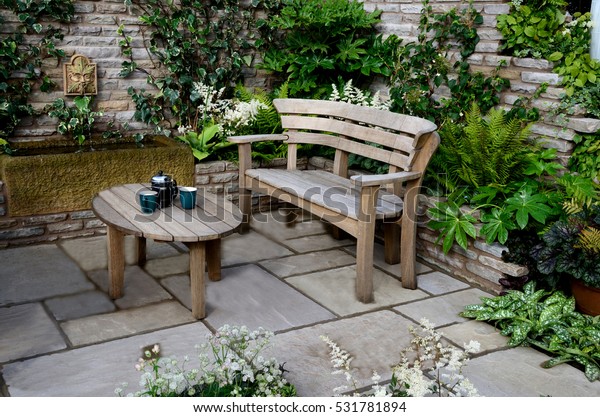 庭の壁に囲まれた庭に座る木造の庭やテーブルを作る小さな庭 の写真素材 今すぐ編集