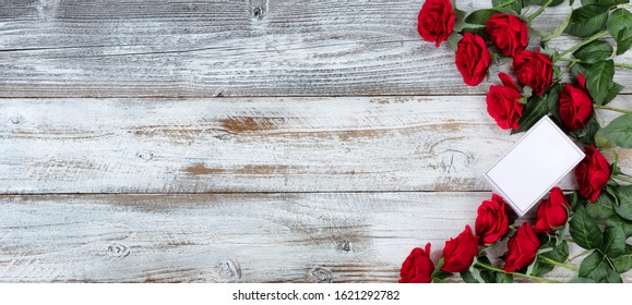 Small Gift Box With A Dozen Red Roses For Valentines Day On White Rustic Wood 