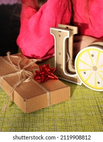 A small gift, in a cardboard box with a red bow, for Valentine's Day. Excerpts of the word love wooden crafts.