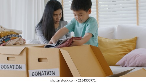 Small gift donate for social issue relief alms unity care at home. Asia little boy kid son and mom smile fun help poor people by reuse old used clean clear closet sort stack box zero waste eco saving. - Powered by Shutterstock