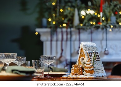 A small gingerbread house with icing, decorated for Christmas. Details of serving a festive feast that create a Festive mood - Powered by Shutterstock