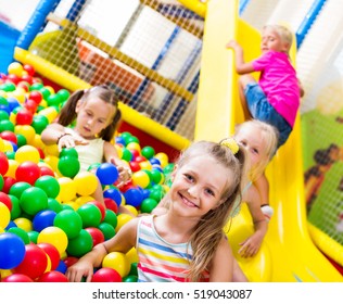 Small girl in elementary school age playing with multicolored plastic balls - Shutterstock ID 519043087