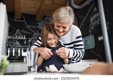 A Small Girl With Grandmother Cooking At Home.