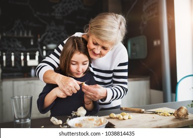 A small girl with grandmother cooking at home. - Powered by Shutterstock