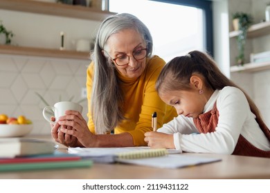 Small girl with grandmother doing homework at home. - Powered by Shutterstock