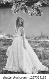 Small Girl Kid With Long Blonde Hair And Pretty Smiling Happy Face In Prom Princess White Dress Standing Sunny Day Outdoor Near Water With Basket