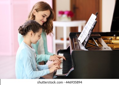 Small Girl Learning Play Piano With Teacher