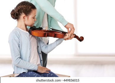 Small Girl Learning Play Violin With Teacher