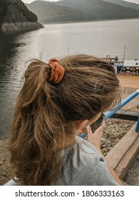 Small Girl With A Messy Ponytail And An Orange Scrunchy.