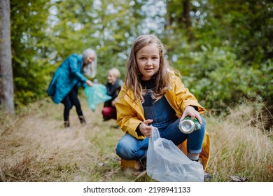 Small girl with mother and grandmother picking up waste outoors in forest. - Powered by Shutterstock