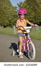 Small Girl On A Bike With Training Wheels