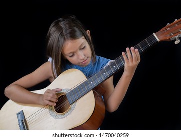 Small Girl Playing Guitar On Black Background