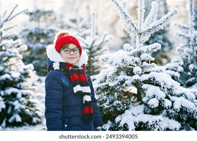 Small girl playing with snow. Happy preschool child in winter forest on snowy cold december day. - Powered by Shutterstock