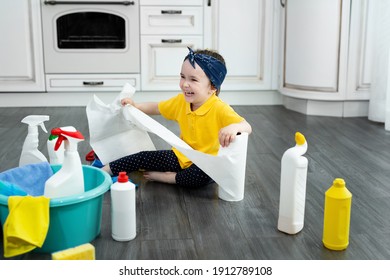 Small Girl Plays With Paper Towels In The Kitchen While Cleaning.