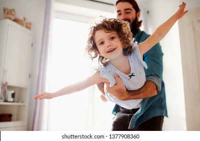Small girl with young father in bathroom at home, having fun.