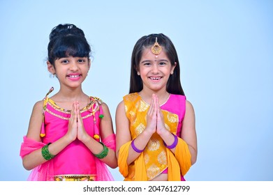 Small girls in indian dress doing namaste with folded hands in greeting pose on the occasion of festivities celebrations - Shutterstock ID 2047612799