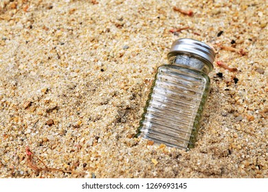 Small glass bottle on the sand - Shutterstock ID 1269693145